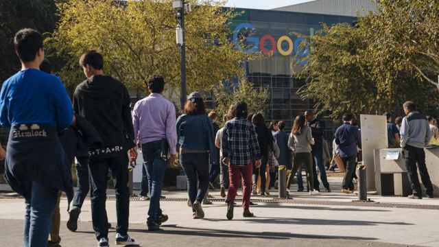 Funcionários do Google fazem protesto em frente a empresa em 2018 após denúncias de assédio sexual; com o logo do Google ao fundo