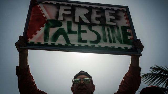 شخص يحمل لافتة كتب عليها فلسطين حرة