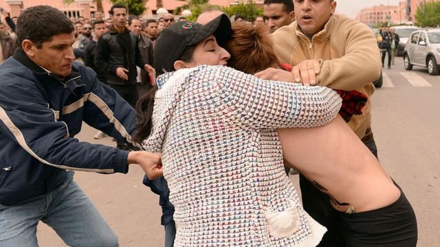 Policías encubiertos arrestando a una activista mientras esta manifestaba frente a la corte de Beni Mellal, durante la audiencia de un juicio de un hombre acusado de ser homosexual.