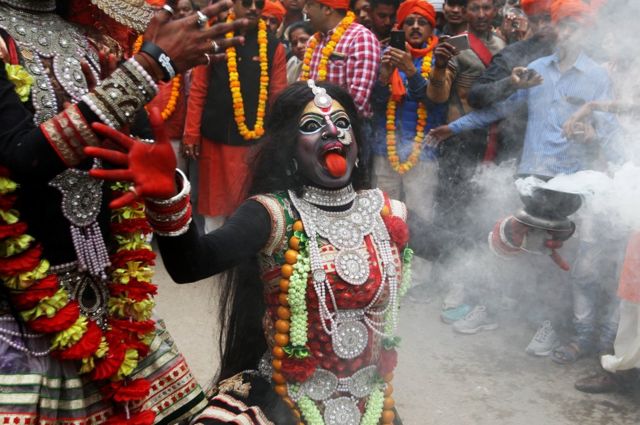 مصل يرتدي ملابس مثل الإلهة كالي في الديانة الهندوسية ويرقص خلال مهرجان ماها شيفراتري في مدينة الله آباد بالهند.