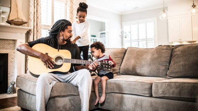 father playing guitar with kids