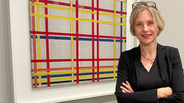 La curadora Susanne Meyer-Büser posa frente a la pintura de Piet Mondrian "Ciudad de Nueva York I" en el museo de la colección de arte de Renania del Norte-Westfalia.