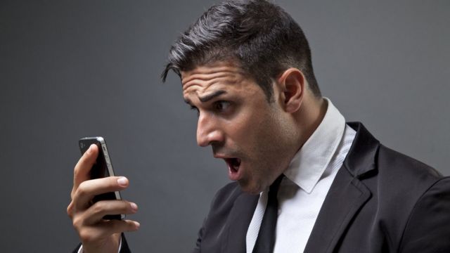 A man looks with surprise at a cell phone