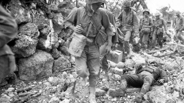 Soldados de EE.UU. pasan al costado de un soldado japonés muerto en Okinawa en 1945.