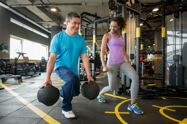 Homem e mulher fazem exercícios em uma academia