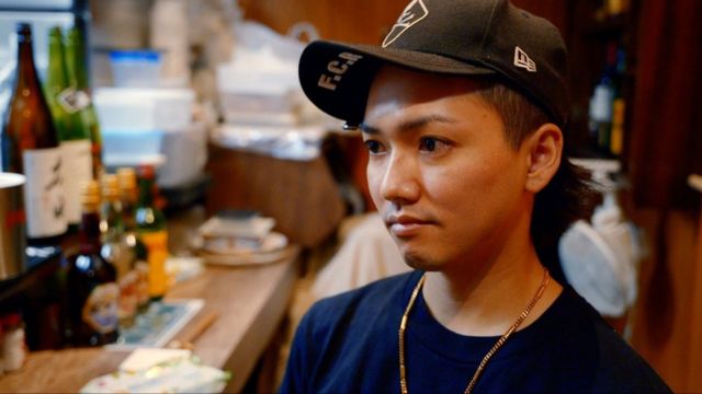 Ryu - joven en el bar con gorra de béisbol.