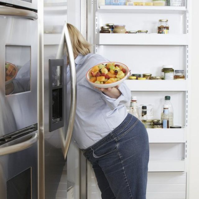 Una mujer busca comida dentro de una nevera