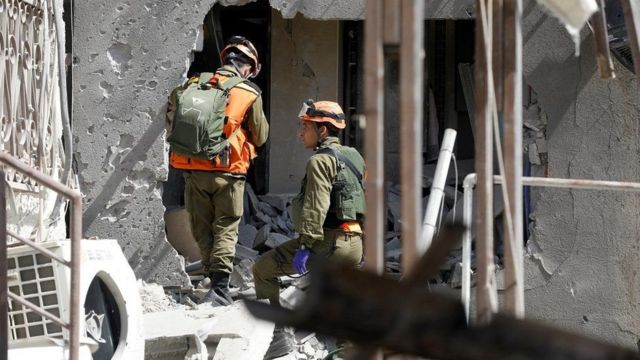 Tentara Israel memeriksa gedung yang rusak di kota Ashkelon akibat roket Hamas.