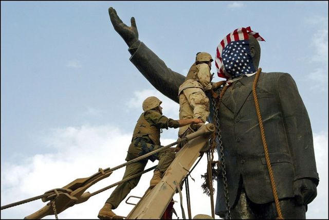 قوات أمريكية تسقط تمثال الرئسي العراقي صدام حسين في وسط بغداد بعد أن أسقط الغزو بقيادة الولايات المتحدة وبريطانيا نظام حكمه.