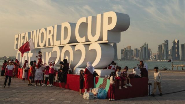 Logotipo da Copa em Doha, com turistas tirando fotos