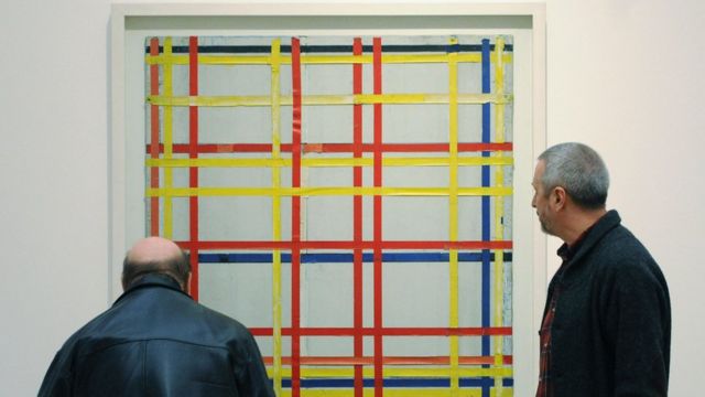 Dos hombres mirando la obra "Ciudad de Nueva York I" de Mondrian.