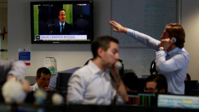 Operadores de mercado trabalham no centro de Londres enquanto David Cameron anuncia que deixará cargo