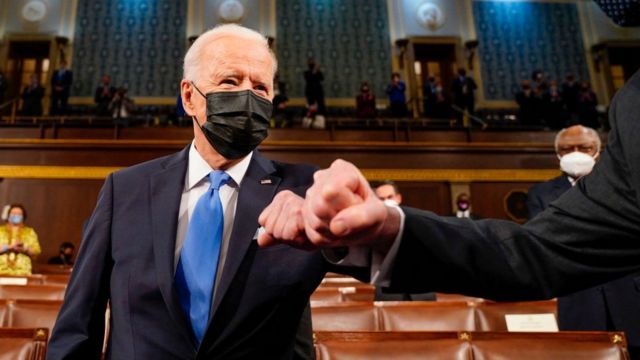 Joe Biden bumping elbows as he walks in to deliver his first speech to a joint session of Congress