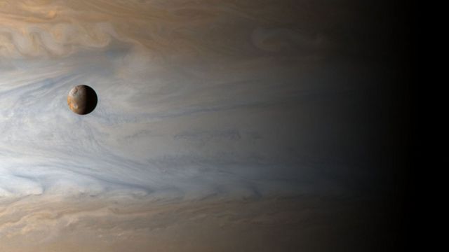 木星的第三大卫星Io，背景是巨大的气态行星木星(photo:BBC)