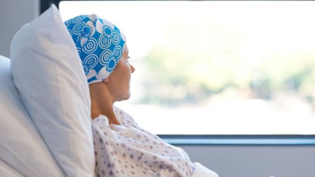 Paciente con cáncer mirando por la ventana