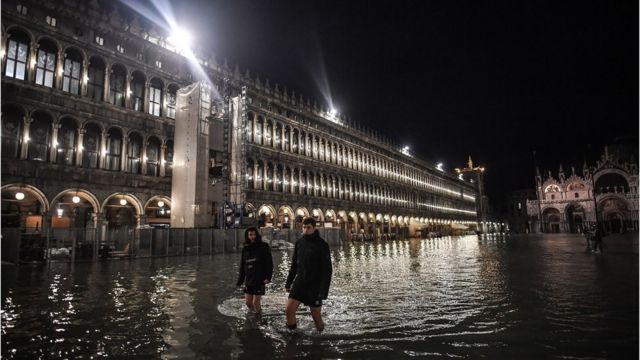 People wade through water in St Mark's Square