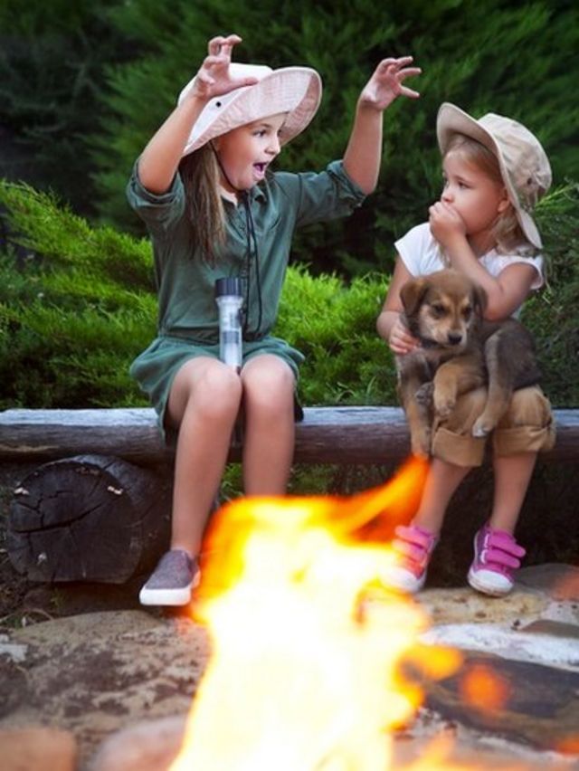 two girls sharing stories by a fire