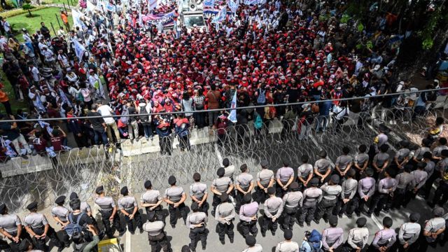 Indonesian activists and workers are blocked by police as they take part in a protest to mark May Day