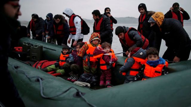 Um grupo de mais de 40 migrantes com crianças embarca em um bote inflável, ao deixar a costa do norte da França para cruzar o Canal da Mancha, perto de Wimereux, França
