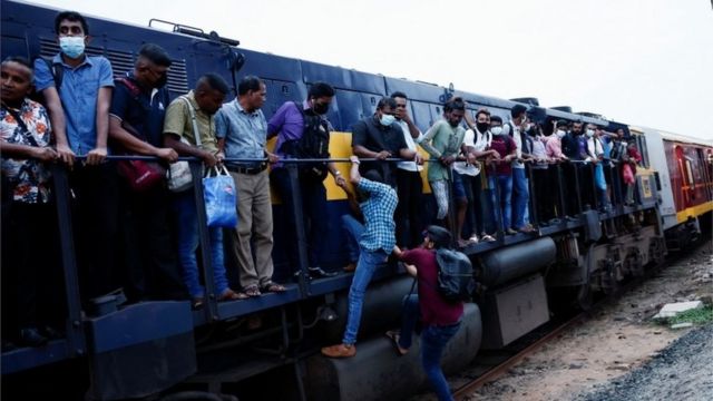 Passenger are helped by others to get to the engine compartment of an overcrowded train as other public transports are being disturbed due to major fuel shortage, amid the country"s economic crisis, in Colombo, Sri Lanka, July 6, 2022.