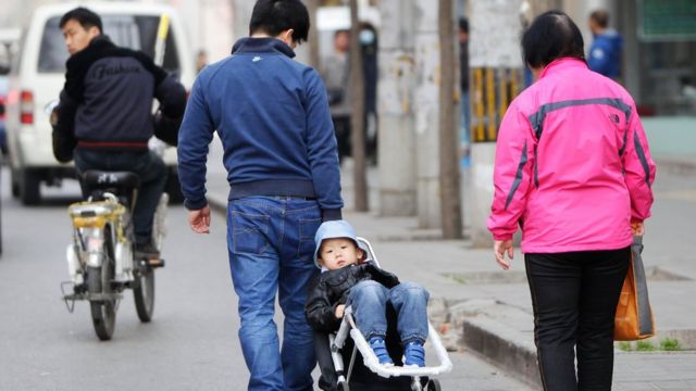 中國一個家庭的父親用拖車帶著孩子
