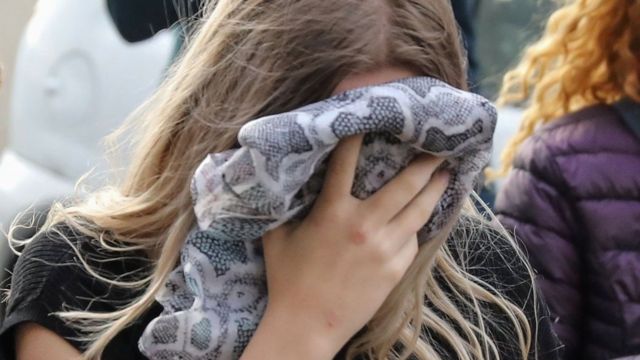 تغطي الفتاة المراهقة وجهها أثناء وصولها إلى المحكمة