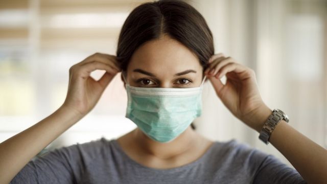 Una mujer se coloca una mascarilla facial.