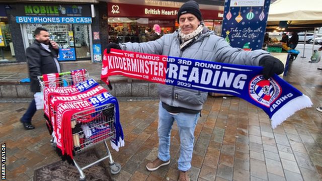 A trader selling half and half scarves before Kidderminster's FA Cup third-round tie with Reading