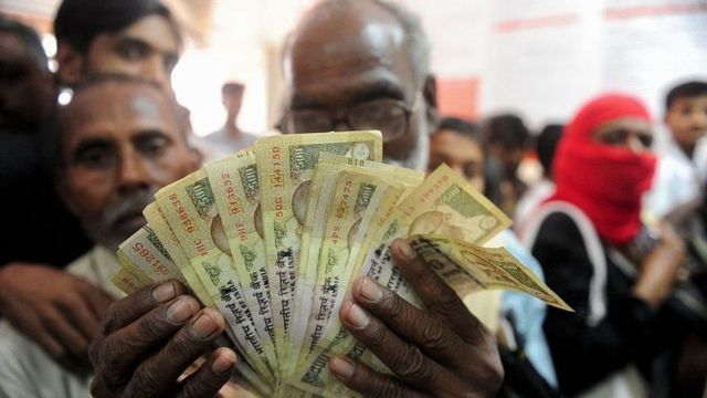 500ની જૂની નોટ સાથે એક વ્યક્તિ
