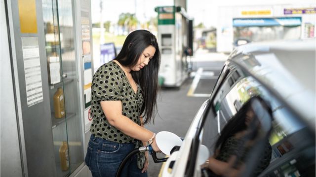 Mulher colocando combustível no carro