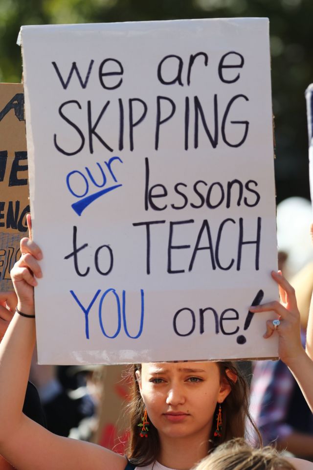 Manifestante con una pancarta que dice: "Faltamos a nuestras clases para enseñarte una lección"