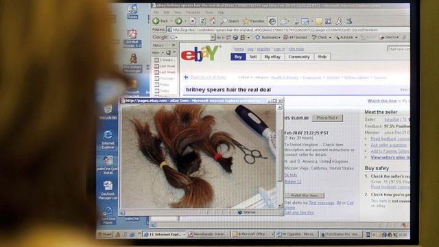 امرأة تنظر إلى شاشة كمبيوتر تعرض صفحة من موقع المزاد على الإنترنت Ebay مع خصلات شعر بريتني سبيرز للبيع، تم تصويرها في 19 فبراير 2007 في لندن.