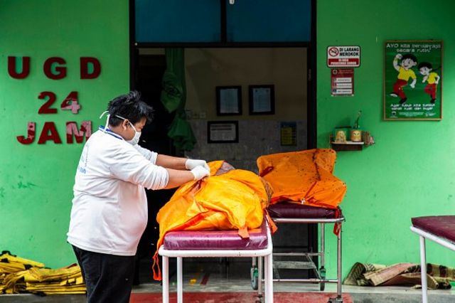 Seorang perempuan memeriksa salah satu kantong jenazah korban tsunami Selat Sunda (24/12). Lebih dari 400 orang tewas tersapu gelombang tsunami yang menerjang pesisir Banten dan Lampung 22 Desember lalu.