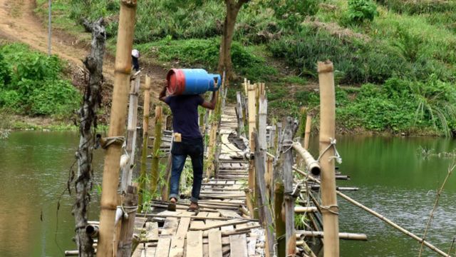 এলপিজি সিলিন্ডার নিয়ে যাচ্ছেন এক ব্যক্তি।