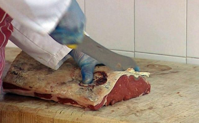 Açougueiro cortando carne