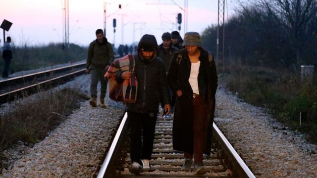 Refugees walk along a railway in Sid near the Serbia- Croatia border as they try to enter Croatia on November 14, 2016