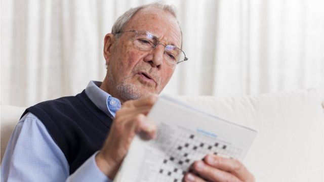 Older man tackling a crossword puzzle