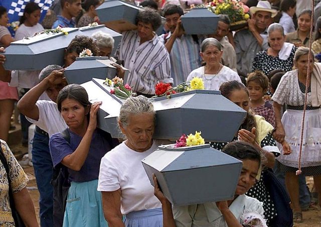 Mujeres cargan ataúdes con restos de las víctimas de la masacre de El Mozote.