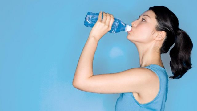 Mujer bebiendo agua.