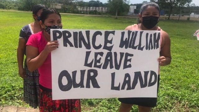 Manifestantes em Indian Creek, em Belize, com um cartaz que diz 'Príncipe William deixe nossa terra'
