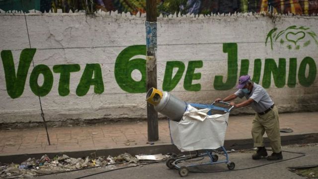 A man walks past a sign encouraging voting in the Mexican elections.
