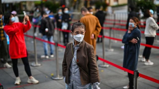 People wearing face masks line up in Shanghai on October 25, 2022.