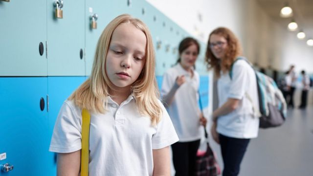 Meninas falando pelas costas de outra em vestiário na escola