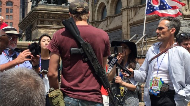 Un hombre muestra su fusil en el inicio de la convención republicana en Cleveland.