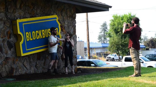 Turistas se toman fotos en el aviso del último Blockbuster.