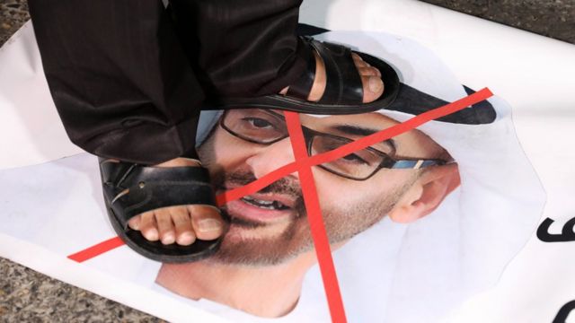 A Palestinian protester stands on a photo of Abu Dhabi Crown Prince Mohammed bin Zayed at a protest in Bethlehem against the UAE's decision to normalise relations with Israel (16 August 2020)