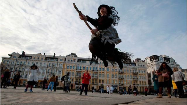 Дівчина в костюмі відьми немов летить на мітлі на Софійській площі в Києві