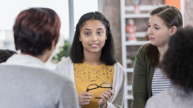 Teenaged girls discuss personal issues with a teacher