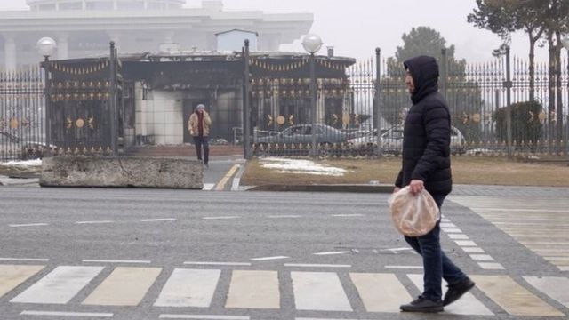 一名男子走过阿拉木图被烧毁的政府大楼。
