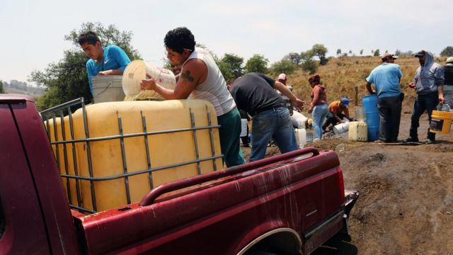 Pobladores abasteciéndose de combustible a partir de un oleoducto de Pemex.